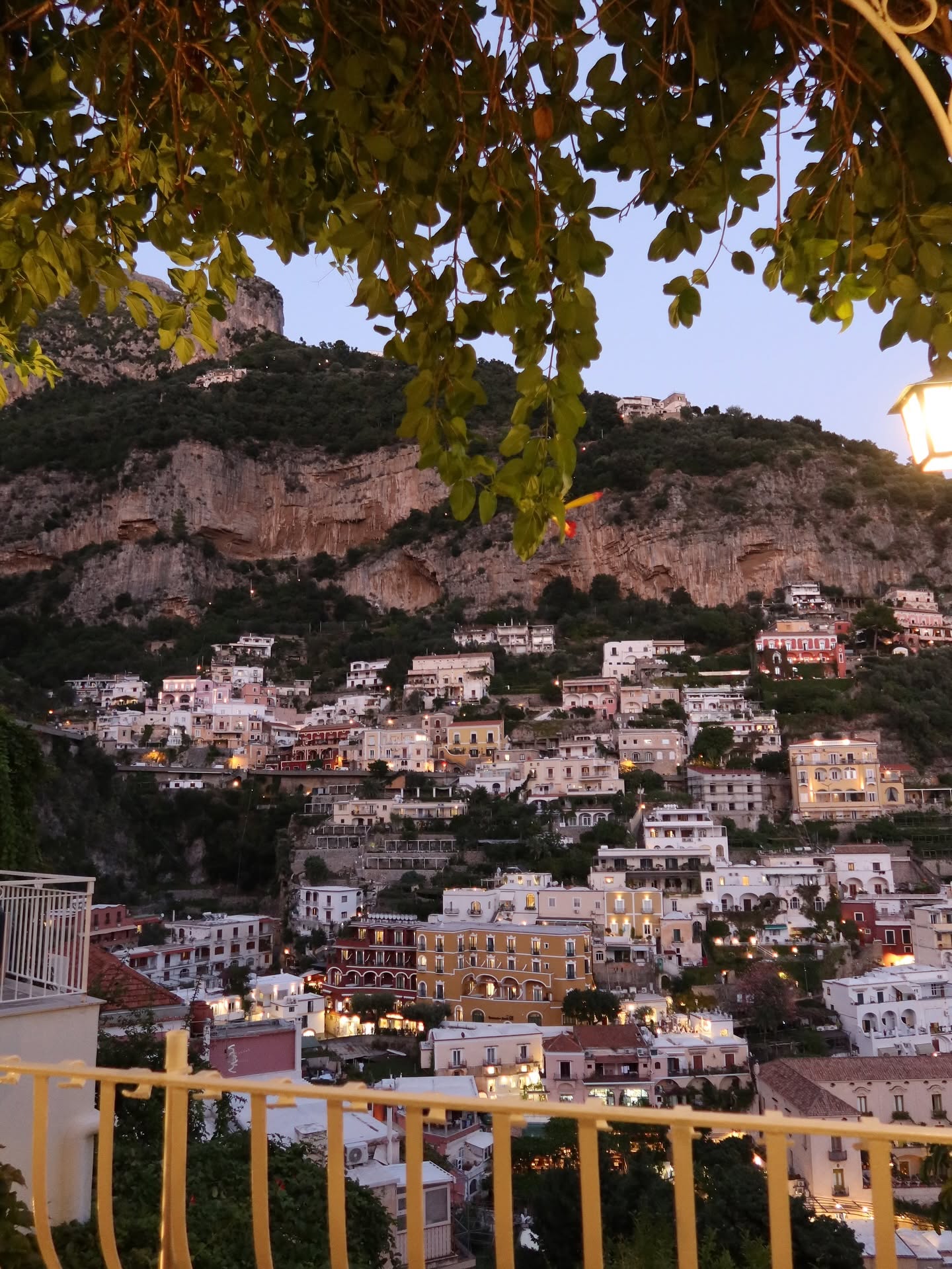 Square: Positano lit up at dusk from a terrace above town